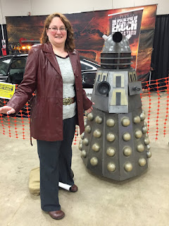 Photo of me cosplaying Donna Noble next to a model Dalek.