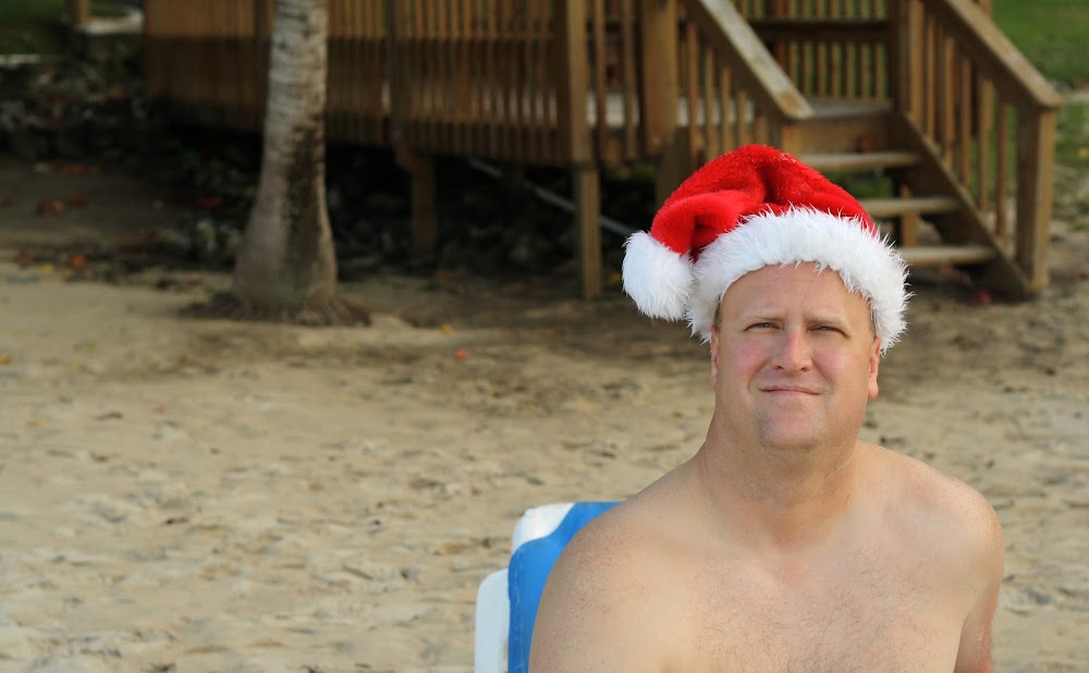 man wearing christmas hat on beach