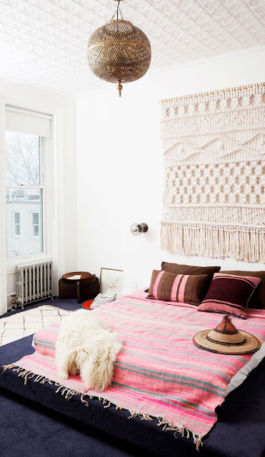 boho chic bedroom with a pink woven rug and large macrame