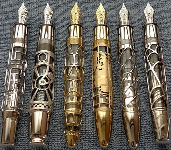 A picture of five MontBlanc Skeleton special edition ink pens, all with ornate designs on them in different types of gold.