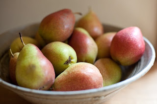 a bowl of red and green pears