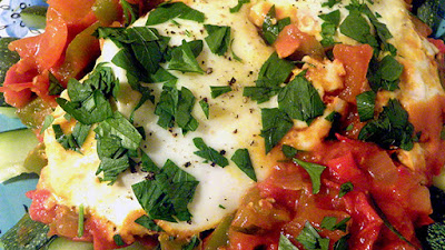 closeup of tomato sauce, eggs, parsley, and black pepper