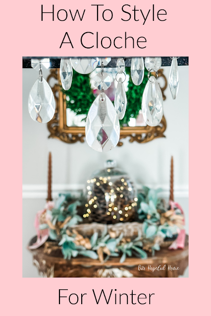 glass cloche filled with fairy lights under chandelier