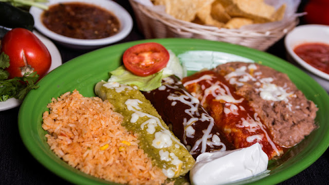 different varieties of enchiladas plated with Spanish rice