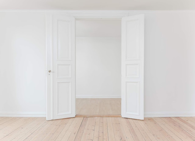 Interior of two double white doors, against white ones with a pale netural floor