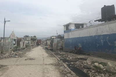 Antiga base da ONU em Cité Soleil (edifício azul e branco) com danos ao redor de um terremoto. Cité Soleil é uma divisão da capital, Port-au-Prince, no Haiti.