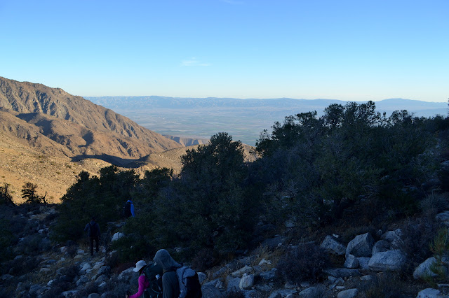 people picking their way down a rocky ridge