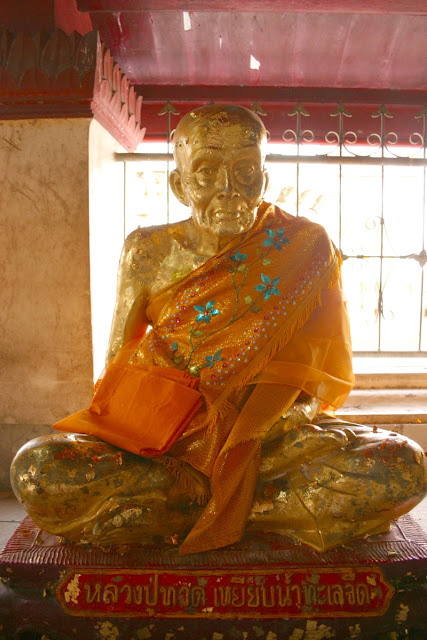 This old monk lived a long life and is decorated with orange sashes.