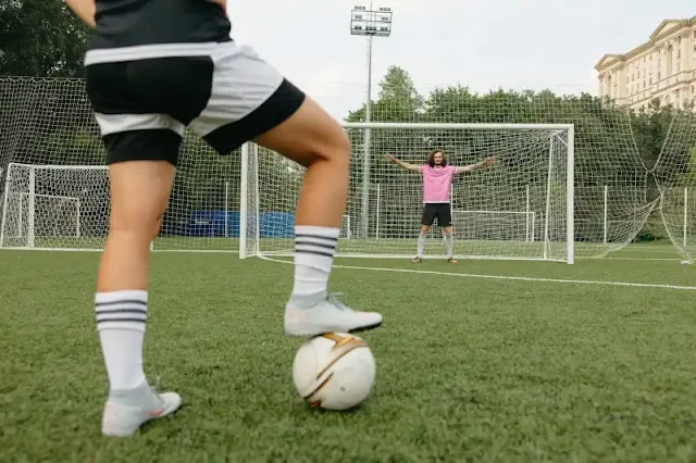 A football player executing a final pass during a match, showcasing skill and precision in a crucial moment.