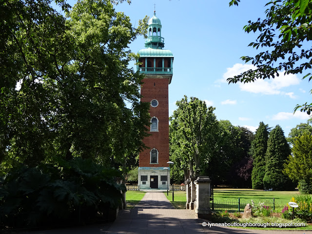 Red brick memorial tower in park setting