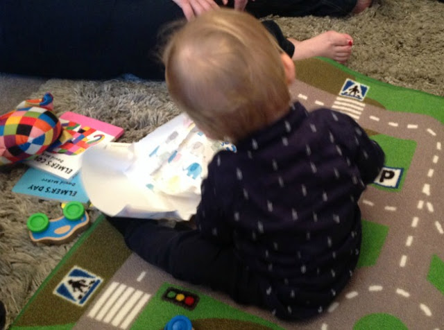 baby sat on floor with presents