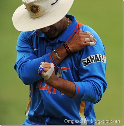 India's Sachin Tendulkar rubs his shoulder shortly after diving onto the boundary rope as he attempted unsuccessfully to save four runs during the one-day international cricket match aga