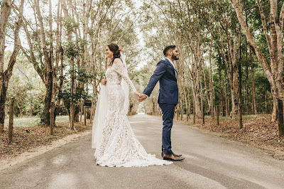 Pareja de novios dándose la espalda, pero tomados de la mano