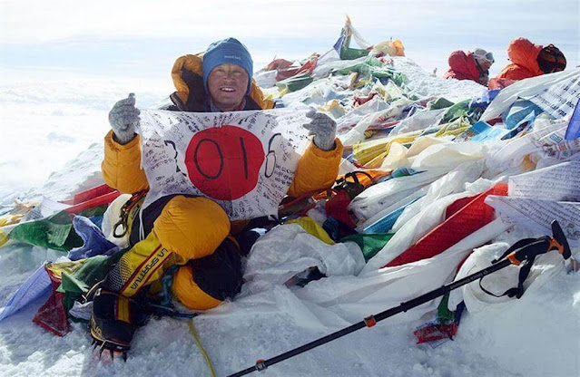 Satoshi Tamura on the summit of Everest with a Japanese flag