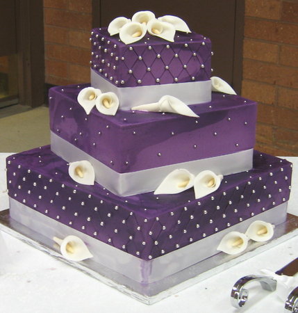 The cake is covered in a purple fondant decorated with brushed embroidery 