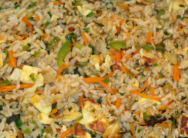 PORCIONES: 3     INGREDIENTES  3/4 tazas de arroz integral  2 y ½ tazas de agua  ¼ cucharadita de sal  1 huevo batido  1 cucharada de aceite de vegetal  1/3 taza de cebolla cortada en cuadritos  1 diente de ajo picado1 cucharadita de jengibre picado  ½ taza de pimientos verdes cortados en cuadritos  1/3 taza de zanahoria cortada en tiritas  1 /4 taza de cebollines cortados delgados  1 taza de espinaca picada      METODO  Lavar el arroz y dejar a escurrir.  En una olla pequeña. Poner el arroz, agua y sal. Hervir el agua, bajar el fuego y dejar cocinar lentamente por alrededor de 45 minutos. El arroz debe quedar blando y haber absorbido el agua.  En una sartén pequeña poner un chorrito de aceite y hacer una tortilla plana. Cortarla en cuadros pequeños.  En una sartén ancha, calentar el aceite y sofreír el ajo con la cebolla.  Añadir y saltear pimientos verdes con la zanahoria.  Agregar y mezclar espinaca.    Incorporar el arroz, huevo y freír por unos minutos sin quemarlo. Dar vuelta al freír.  Sazonar con un poquito de sal o salsa soja.