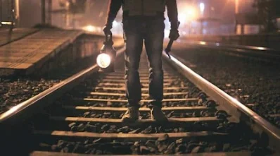 homem caminhando linha de trem