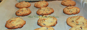 these are a buttery peanut butter homemade from scratch cookie with chocolate chips in them. These are how to make the best ever peanut butter chocolate chips cookies. These cookies are on a cookie sheet with parchment paper on them so they wont stick and are easy to remove after cooling.