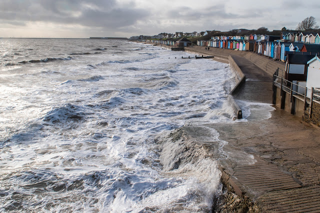 Colourful beach huts and wild water