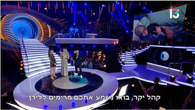 "האח הגדול" 4:  לירן מודחת מבית האח ויוצאת לבמה. המנחה גיא זוארץ: "קהל יקר, בואו נשמע אתכם מרימים ללירן." (הכתובית לא במקור. האח הגדול 4, רשת, 2022)