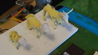 Photograph of three goat models with foam bodies and clay heads.