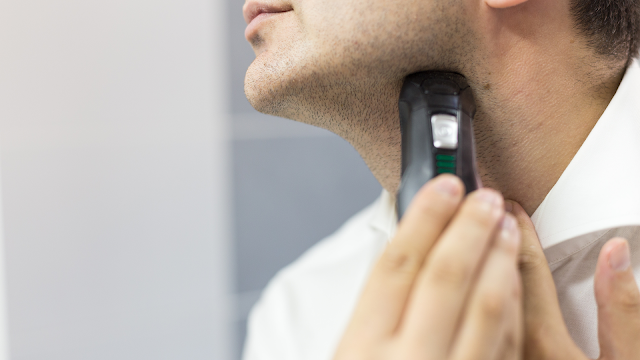 Man using electric shaver