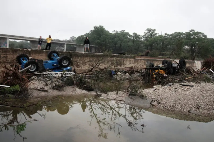 KERRVILLE (Estados Unidos), 05/07/2025. – Pessoas observam os danos causados pelas enchentes em Kerrville, Texas, EUA, em 05 de julho de 2025. Vinte e sete pessoas foram confirmadas mortas e dezenas estão desaparecidas após as águas da enchente varrerem um acampamento de verão e residências próximas na madrugada de 04 de julho. As equipes de busca e resgate continuam trabalhando sem parar após a inundação repentina do rio Guadalupe, no condado de Kerr. (Foto: Dustin Safranek/ EFE)