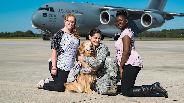 Lt. Col. (Dr.) Regina Owen (center), and former colleagues from the 436th Medical Operations Squadron at Dover Air Force Base, Del., took part in the 436th MDOS Family Advocacy Domestic Violence Awareness Month with facility dog, then-Lt. Col. Goldie. (U.S. Air Force photo by Roland Balik)