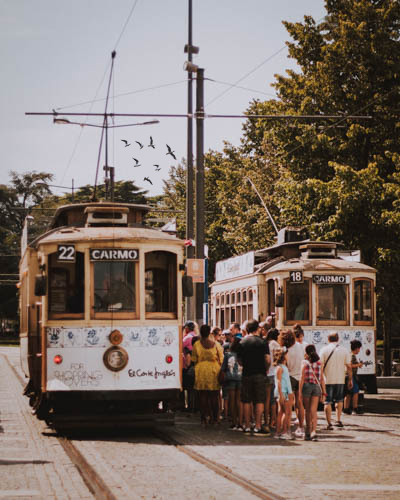 turistas a entrar num antigo carro eléctrico para o passeio junto ao rio