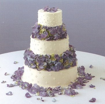 Three tier round wedding cake with lilac blue hydrangeas