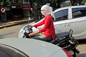 girl with white scarf and mask on scooter