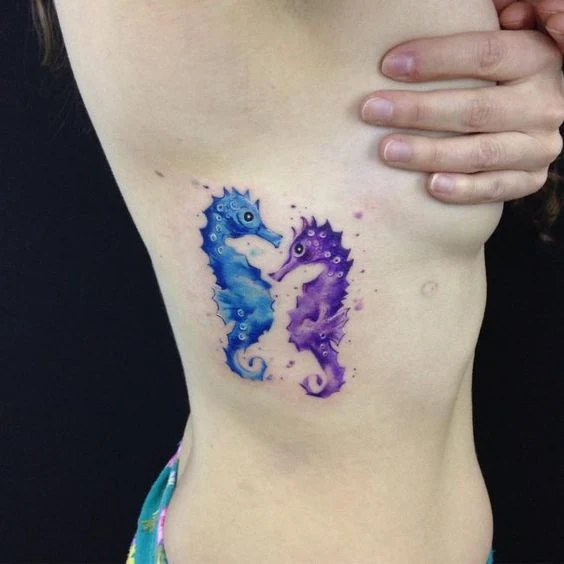 Una mujer con un tatuaje de dos caballitos de mar en las costillas