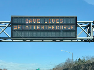 Road sign: Save Lives. Flatten the Curve.