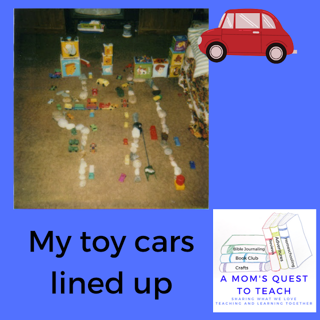 Text: My toy cars lined up; logo of A Mom's Quest to Teach; plastic cars lined up on floor with rocks as roadyways