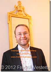 DSC02518 (1) Fredrik Vesterberg i mörk kavaj vid guldspegel. Med amorism