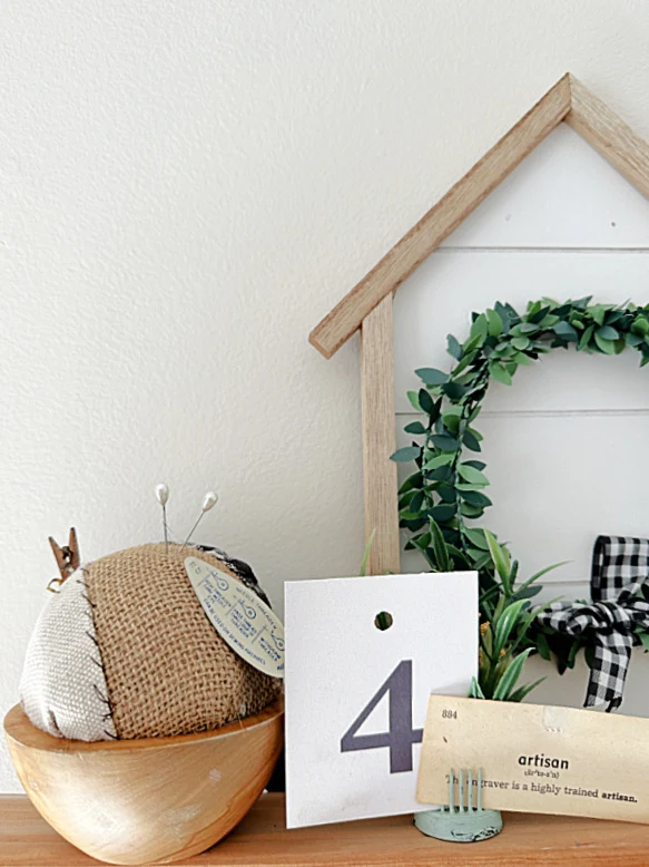 shelf with number, pincushion and house with wreath