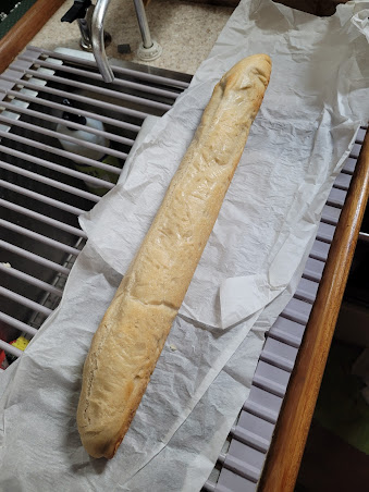 A lovely browned loaf of bread sits atop parchment paper in the galley.  Too bad you can't smell it!