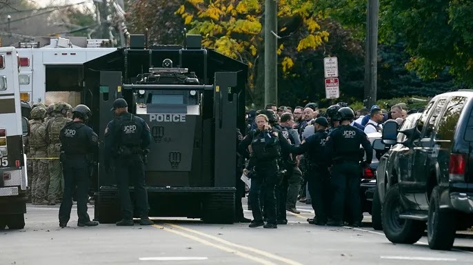 Law enforcement personnel gather at the scene where two officers were reported shot, Tuesday, Nov. 1, 2022, in Newark, New Jersey.   (AP Photo/Seth Wenig)