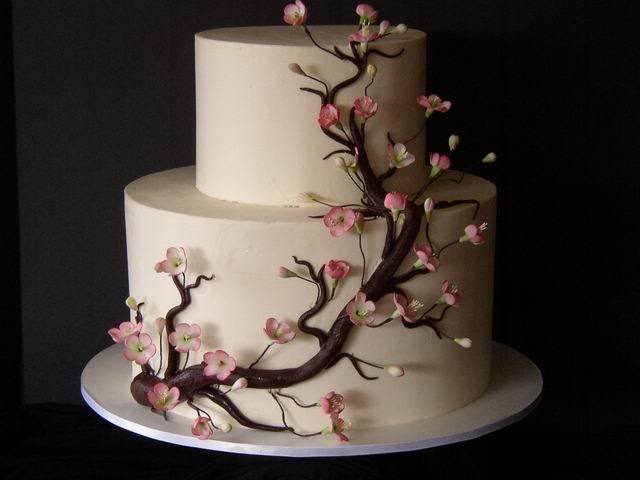 Gorgeous two tier round wedding cake in white with pink cherry blossoms
