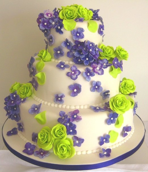 Three tier white chocolate shavings wedding cake decorated with purple 