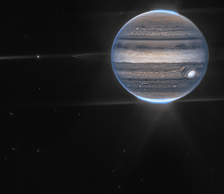 This false-color composite image of Jupiter was obtained 07/27/22 with the NIRCam instrument on board the JWST. Jupiter’s faint rings — a million times dimmer than the planet — and two of its small satellites, Amalthea (left) and Adrastea (dot at edge of ring), are clearly visible against a background of distant galaxies. The diffraction pattern created by the bright auroras and the moon Io (to the left out of the image), form a complex background of scattered light around Jupiter.