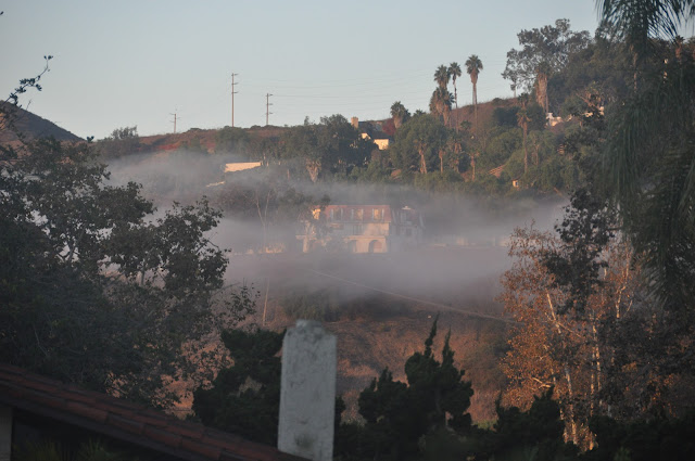 A house on a hill with a wisp of fog hanging in front of it