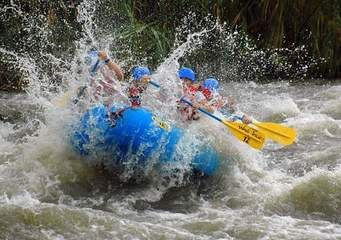 White-water raft crashing down in deep water engulfed in large splash