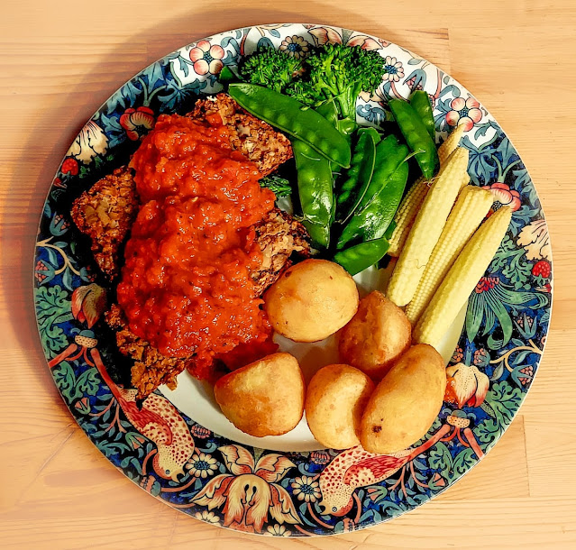 Nut roast with red pepper sauce, roast potatoes and vegetables