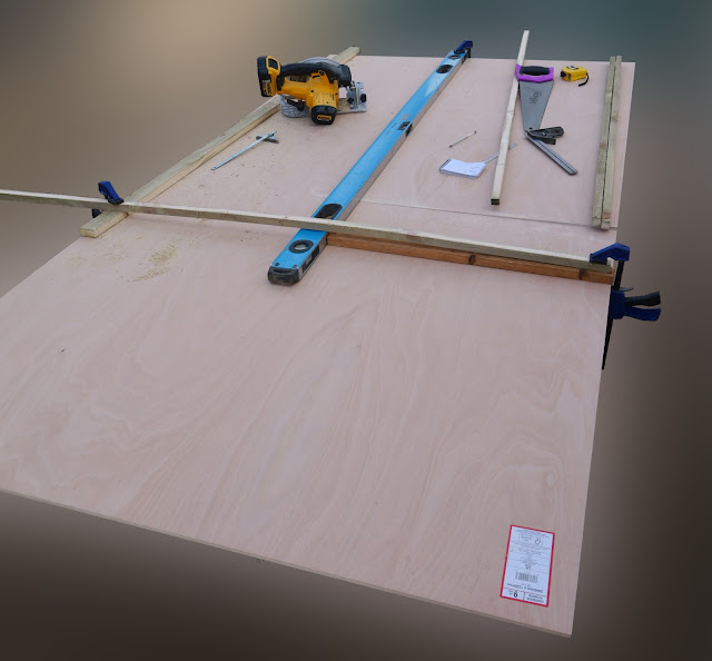 The same piece of plywood is shown with clamped bits of wood securing a spirit level.