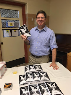 Author and artist, David Borden, standing behind a table of books: And Yet We Rise.