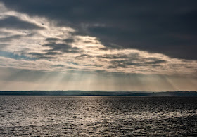 Another shot of the sun breaking through heavy clouds over the Solway Firth