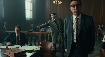 A man enters a courtroom to kill Jimmy Hoffa (Al Pacino) while Bill Bufalino (Ray Romano) has his back turned in a movie scene for The Irishman, a Netflix original directed by Martin Scorsese