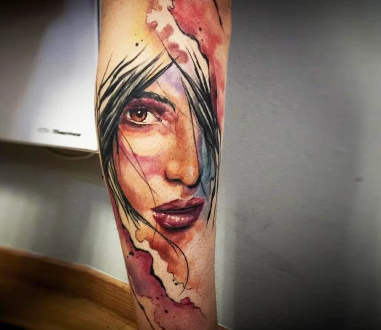 Tatuaje de un rostro de mujer melancólica en acuarelado