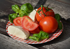 a plate of summer tomatoes, basil, and mozzarella cheese